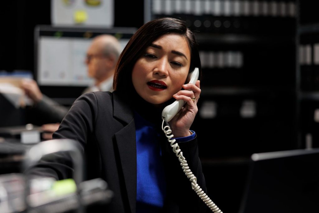 Professional businesswoman taking calls using cloud based phone systems in a busy corporate office environment that was Made it Easy with iNet