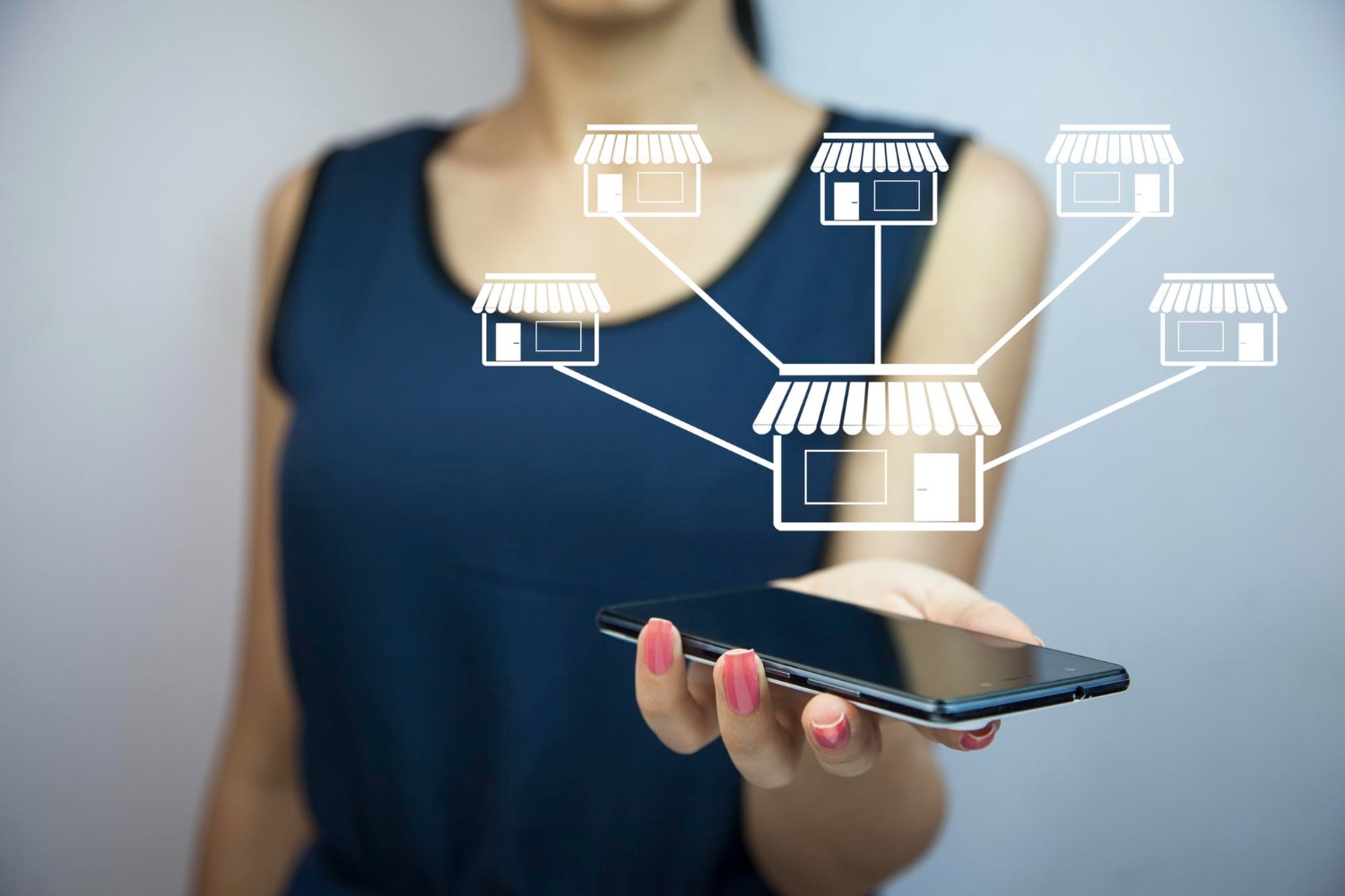 A woman in a navy dress holds a smartphone with illustrated icons of storefronts branching from it, visualizing scalable IT infrastructure and reliable internet solutions for managing multi-location business internet connectivity.